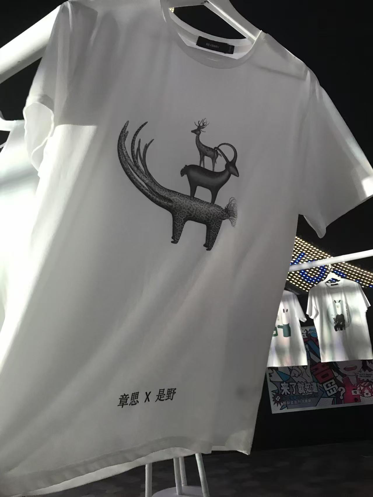 上海大悦城 T-shirt 展示现场，衣服上印有章愳作品图像